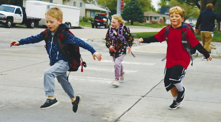 ST. PAUL STUDENTS Connor Berggren, Roger Rice, and Marissa Moore dodged water puddles as they made their way to school as a part of St. Paul Public Schools’ Elementary Walk to School Day. More than 100 students participated in the event. Photos by Michael Rother