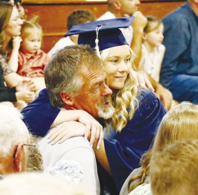 RAEGYN JARMAN gives a hug to her grandfather, Marvin Caudill, during the flower presentation segment of last Saturday’s Central Valley High School commencement exercises. Photos by Michael Rother