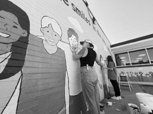 LANNA VANWINKLE AND HAILEY DUPLER retouch a mural at Literacy Council of Grand Island during Heartland United Way’s Annual Day of Action on Thursday. More than sixty volunteers took action for their community during the event last week. Courtesy Photo
