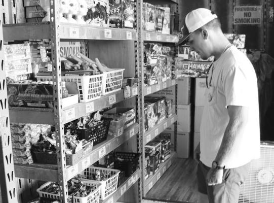 FIREWORKS SALES kicked off in St. Paul over the weekend, with vendors opening their booths to customers on Sunday for the first time. Above, Cole Epp browses the offerings at Peter’s Poppers near the Pizza Hut in St. Paul on Monday afternoon. Firework sales run through the Fourth of July. Photo by Michael Rother