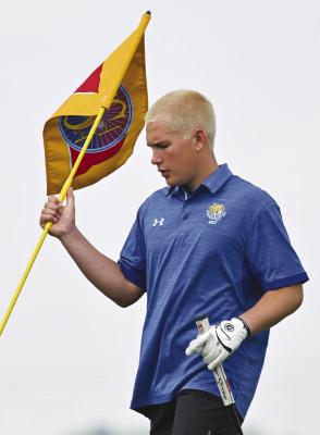 SAWYER KAVAN replaces the flag on the twelfth hole at the NSAA Class C State Golf Championships in Grand Island last week.