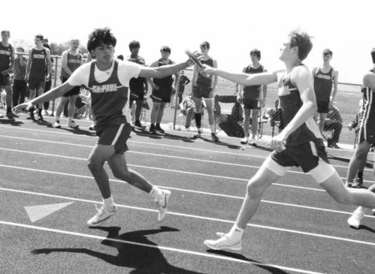 ST. PAUL’S RYLAN RAMUSSEN makes the first exchange with Bobby Rojo during the boys’ 3200-meter relay at last week’s Ron Priebe Invite at Gibbon. The Wildcats won the relay race in 8:49.46. Photos by Monte Steele