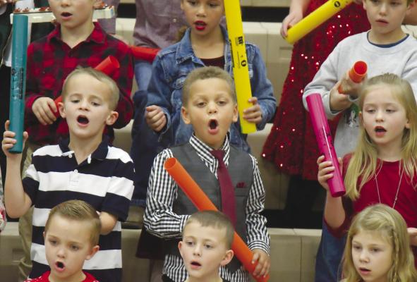 ST. PAUL first graders Dallas Solko, Dean Washington, and Charlie Boehle sang right along with their classmates during last week’s holiday concert at St. Paul Elementary School. Photos by Michael Happ