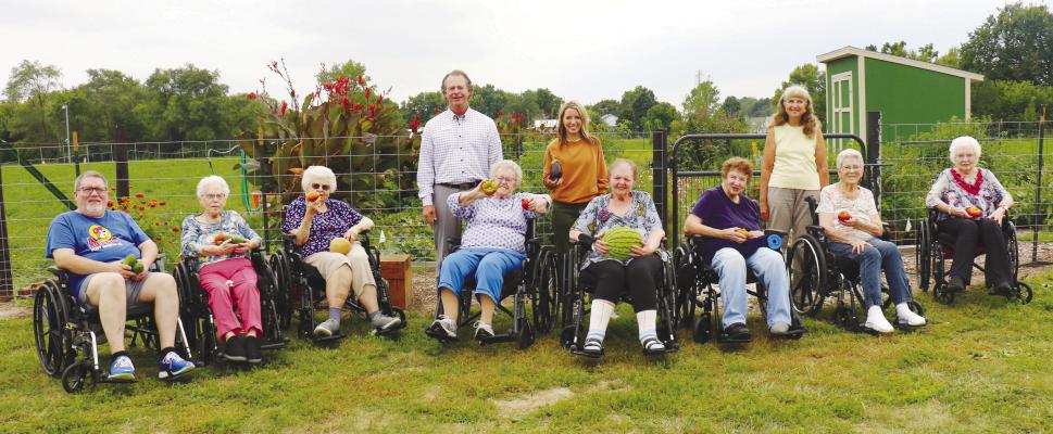 SHOWING OFF SOME PRODUCE harvested from the Rotary Club of St. Paul’s community garden last week are (front row) Brookefield residents Larry Rasmussen, Phyllis Stepanek, Corrine Nekoliczak, Nancy Donovan, Elaine Stobe, Catherine Sweeney, Maedean Mathews, and Darlene Schultz; and (back row) Brookefield Park Administrator Rob Foxworthy, Brookefield Park Life Enrichment Coordinator Melissa Butt, and Rotarian Roxie Lehman. Photo by Michael Rother