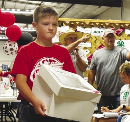 EASTON MEYER shows off his cake during the Howard County Fair’s Decorated Cake Auction on Sunday night. The Howard County Fair got underway on Saturday and runs through Wednesday evening. Photo by Michael Happ