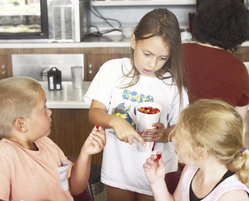 SUMMER SCHOOL PARTICIPANT Aria Sydzyik shares her Mike and Ikes with Raider McClay and Marissa Moore last Thursday. Sydzyik won the candy as a part of a guessing game during the group’s visit to the Skyline Cafe. Photos by Michael Happ