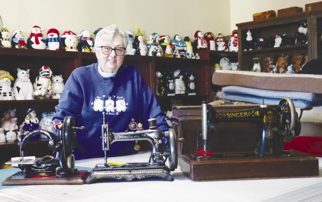 DEE KUSZAK of rural St. Paul is pictured alongside several of her historic sewing machines, including an F.C. Henderson Co. chain stitch sewing machine (far left) that she recently restored and a lockstitch W.J. Harris Defiance machine (center) she is in the process of restoring. Photo by Michael Rother