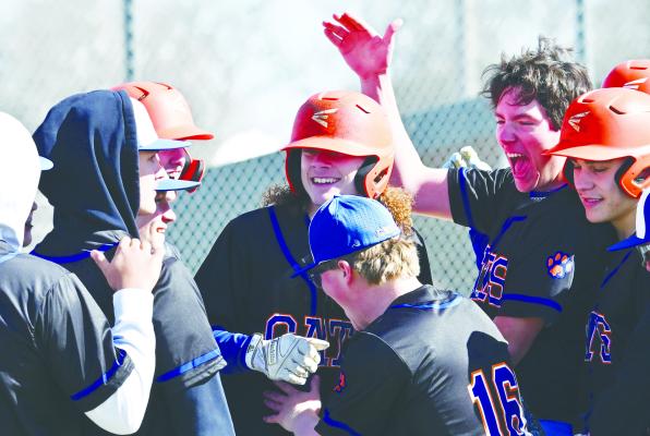 MEMBERS of the St. Paul/Palmer Cats baseball team celebrate at home plate after Zandyn Weller hit a home run on the program’s third pitch of the season. Weller’s homer spurred one of two runs the Cats tallied on opening day against York in St. Paul. Photos by Michael Happ