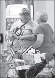 HARRIET STEENSON assists a customer at the Wolbach Community Center on Saturday. Photos by Michael Rother