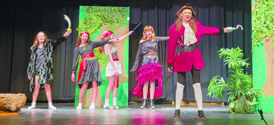 ADDIE BERST, as Captain Hook (right), acts out a scene from the St. Paul Public Schools All School Play during a rehearsal last week while her loyal pirates—Jordyn Eytcheson, Taya Alberti, Aubry Caudill, and Evie Partick—watch on. Courtesy Photos
