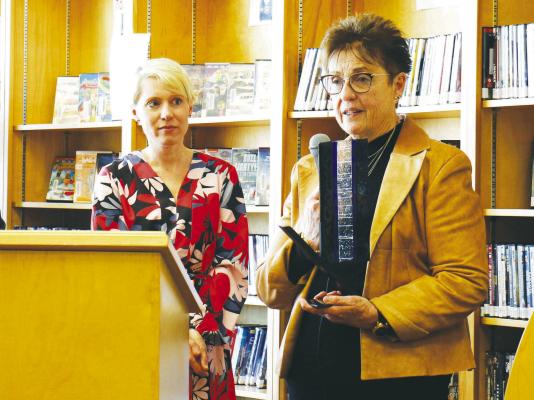 ART INSTRUCTOR CATHY LEMMERMAN shows off the NebraskARTS award from Nebraskans for the Arts during her remarks at last week’s ceremony. Lemmerman, who is pictured next to Nebraskans for the Arts Executive Director Petra Wahlqvist, spoke during the awards ceremony at the library. (Michael Rother)