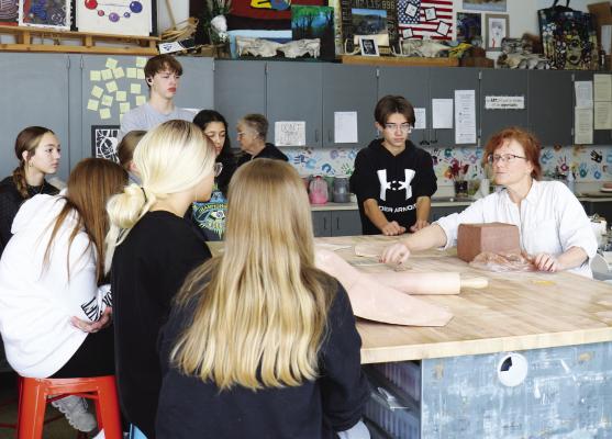 ARTIST IN RESIDENCE Nancy Fairbanks leads Art 1 students in a lesson about the makeup and natural history of clay, as well as a demonstration of how to work with the material, before the students begin their work on clay slab pots. Photo by Michael Rother