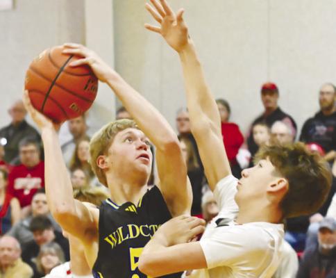 ST. PAUL’S CONNOR DOUTHIT battles his way to the rim during the Wildcats’ game against Arcadia/Loup City. Douthit had one of just three two-point baskets for St. Paul in the contest. Photos by Michael Happ