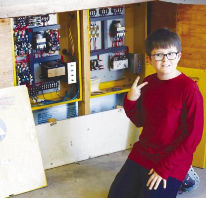 DREW DYE of Abilene, Texas poses for a photo next to the control panel for the warning siren at the St. Paul fire hall. Photo by Michael Rother