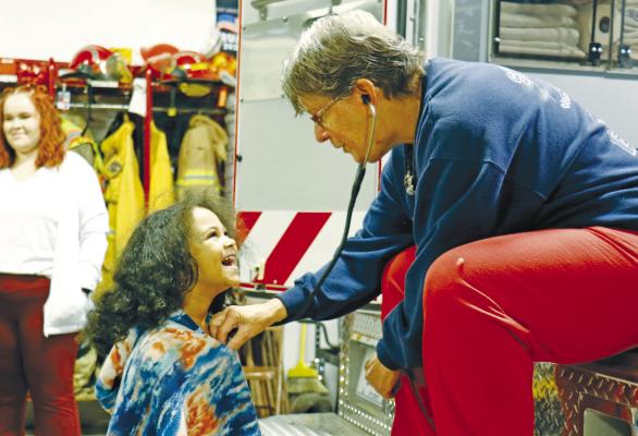 STUDENTS at St. Paul’s Little Paws Preschool had a chance to learn all about fire prevention and safety last Thursday when they made a visit to the St. Paul Volunteer Fire Department. Above, St. Paul EMT Deb Meyer listens to Monica Wellons’s heartbeat during a stethoscope demonstration at the fire hall. See more coverage of National Fire Prevention Week on page four of this week’s newspaper. Photo by Michael Rother