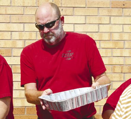 CITIZENS BANK AND TRUST CO. President Jeff Varney helps replenish the serving line last Tuesday afternoon during the bank’s community barbecue.