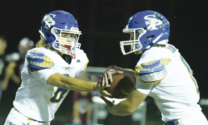ST. PAUL Quarterback Zandyn Weller hands off the ball to Gage Sack during the first quarter of last Friday’s cross country rivalry game between St. Paul and Centura. Photos by Michael Happ