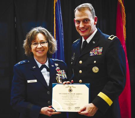 MAJOR GENERAL WENDY JOHNSON (left) and Adjutant General of the Nebraska Military Department Craig Strong (right) hold a certificate of the Distinguished Service Medal awarded to Johnson for her service. Courtesy Photo