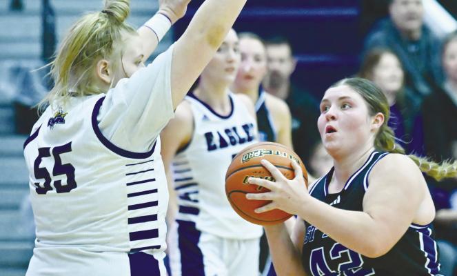TESSA DUGAN navigates around a Wood River defender on her way to the rim for a fourth-quarter basket last Thursday night during the Wildcats’ game against the Eagles. Photo by Michael Happ