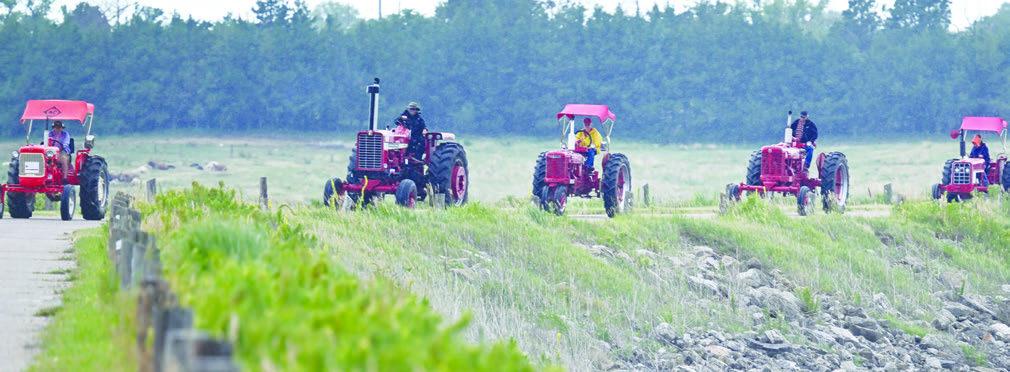 MEMBERS of the Central Nebraska Antique Tractor and Equipment Club make their way across the dam at Sherman Reservoir on Friday morning during the club’s annual tractor drive. Thirty-two tractors and sixty-five people participated in this year’s event. Photo by Michael Happ