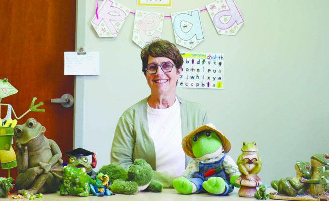 KELLIE SEWARD sits at a desk in her room at St. Paul Elementary School surrounded by just a few of the frogs she has been given by her students, their families, and her colleagues. When she started teaching forty-one years ago, the retiree had been asked to choose a theme for her classroom. She chose frogs, and the association has stuck. Photo by Michael Rother