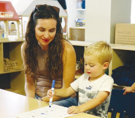 WILL HARDERS colors while his mom, Danielle, watches during orientation night at Little Sprouts in St. Paul. Photo by Michael Rother