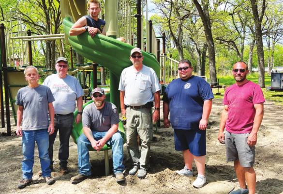 HELPING erect the new playground at the Danneborg Park last month were Steve Lehn, Verlen Larsen, Chris Donahoo, Terry Webb, Devin Wilkins, Supervisor Jared from Crouch Recreation, and, in the slide, Josh Webb. Also volunteering with the project, but not pictured, were Hans Christiansen, Mike Pritchard, Kelly Burgess, Tim Hannibal, Ann Best, Mike Burgess, and Lori Larsen. (Courtesy Photo)