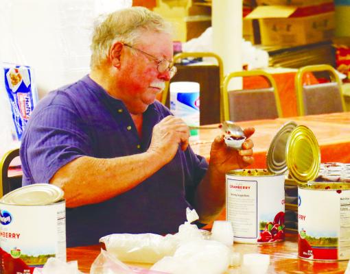 RANDY THOMSEN works to portion out cranberries on Wednesday afternoon as a part of the early preparations for the St. Paul Community Thanksgiving. The event was noted to be another success this year, thanks, in part, to the many volunteers who participated. Photo by Michael Rother
