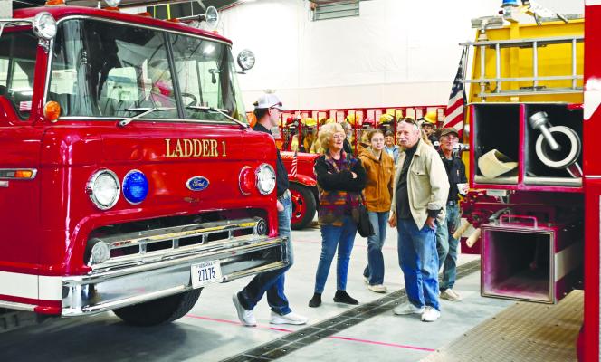 ST. PAUL FIREFIGHTER NATHAN BECKER speaks to Carolyn and Mick Tyma on the apparatus floor of the St. Paul Fire Department and Rescue Squad’s new fire station on Fourth Street during Sunday’s open house. Photos by Michael Happ