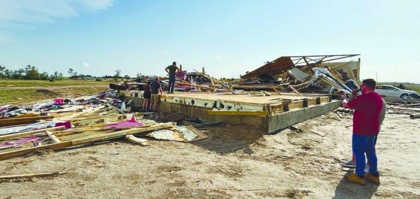 INDIVIDUALS SURVEY DAMAGE to a home at Denton Road and 7th Avenue earlier this week. A tornado caused damage to four homes in the area and across parts of Howard County on Sunday afternoon. Courtesy Photo