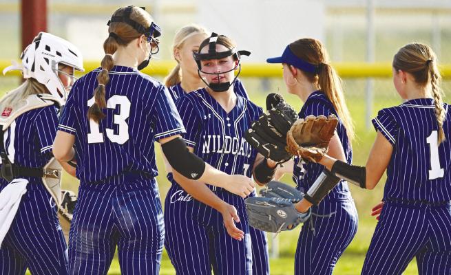 MEMBERS of the St. Paul softball team congratulate pitcher Addy Wegner following a strikeout early in last week’s game against Centennial. Photos by Michael Happ