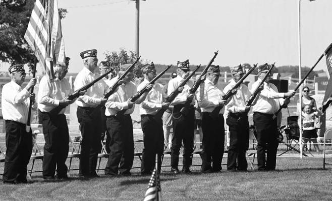 MEMBERS of the Carl Mogensen American Legion Post 119 Honor Guard rendered the salute during Monday morning’s services at Elmwood Cemetery in St. Paul. A sizable crowd attended this year’s Memorial Day service, which was graced by warm weather and sunshine. Photo by Michael Happ