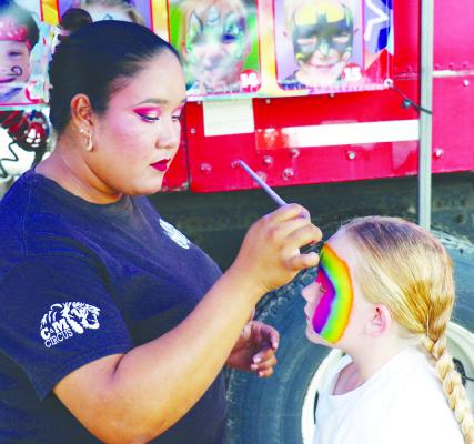 LILLYDAWN JENSEN gets her face painted on Saturday, one of several activities offered on the midway.