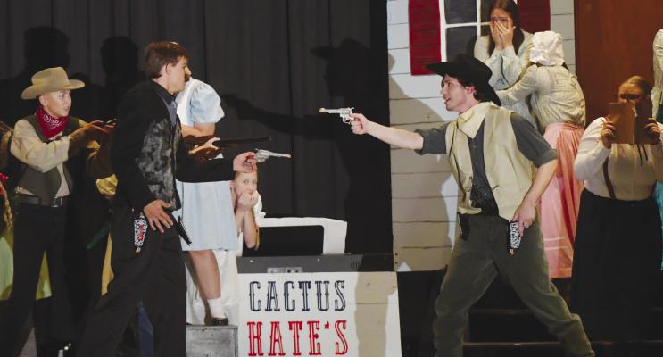 SMILING SLADE CLAGGETT (Ian Crawford, left) and his band of outlaws, including Straight Shooting Sam (Carson Harder, far left), get into a shootout with Chuck Wagon (Cove Engleman, right) outside of Cactus Kate’s during the Centura one-act troupe’s staging of Westward, Whoa! at the Central Valley One-Act Festival last week. Photos by Michael Rother