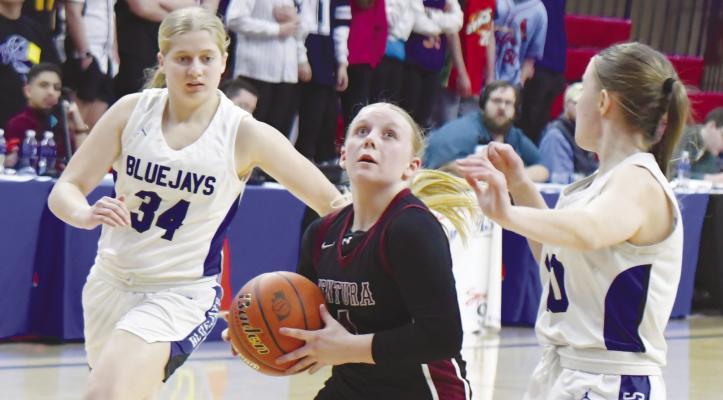 KYRA WOODEN threads past a pair of Bluejay defenders during the third quarter of last Thursday night’s quarterfinal game of the NSAA Class D-1 State Basketball Tournament at the Bob Devaney Sports Center in Lincoln. Photos by Michael Happ