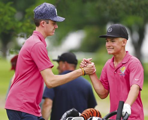 MADDOX QUINN congratulates Casen Kavan after the sophomore sinks a putt on the eighteenth hole of the state championship course on Thursday afternoon in Grand Island.