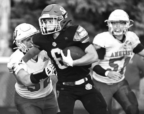 ZANDYN WELLER fights for yards during the first quarter of last week’s game between St. Paul and Amherst. Despite both a strong night in the air and on the ground by the senior, the Wildcats fell to their guests 14-7. Photos by Michael Happ