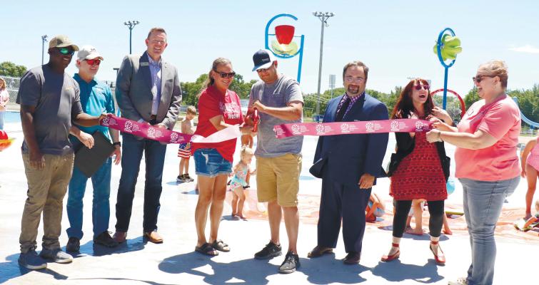 CUTTING THE RIBBON on Wolbach’s new playground and splash pad project last Thursday were Mario Robinson, Larry Steele, Josh Jelden, Shelby Steenson, Matt Steenson, Jerad Reimers, Chelsea Egenberger, and Carla Kimball. Photo by Michael Rother