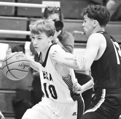 ELBA’S KJELL BROCKHOFF drives past Palmer’s Bruno Navarro during last Thursday’s game in Elba. The Tigers topped the Bluejays 60-26. Photo by Michael Happ