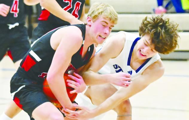 ST. PAUL’S JOEL SHAFER attempts to make a steal during the first half of last Thursday’s game between St. Paul and Arcadia/Loup City. Photo by Monte Steele