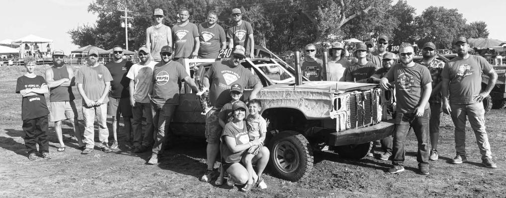 PARTICIPANTS in this year’s Watermelon Days Demolition Derby in St. Libory gathered together to recognize Sutton Hake of Palmer as the derby’s top fan. Above, Hake is pictured with the drivers during this year’s derby, who wore their blue—the color of Leukodystrophy awareness—Sutton Squad t-shirts in support of the Palmer youth. Courtesy Photo