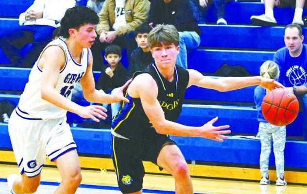 ST. PAUL’S MAX MEYER dribbles past a Gibbon defender on his way down the baseline towards the hoop during the second quarter of last Thursday night’s game against Gibbon. Photo by Michael Happ