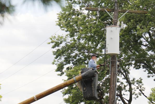 ST. PAUL Electrical Commissioner Ed Thompson works to repair power lines along Sheridan Street following last Saturday evening’s severe storm. (Michael Happ)
