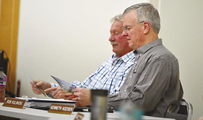HOWARD COUNTY PLANNING AND ZONING COMMISSION members Randy Kauk and Ron Kulwicki look over the survey brochure during last week’s town hall meeting at the St. Paul Library. Photo by Michael Happ