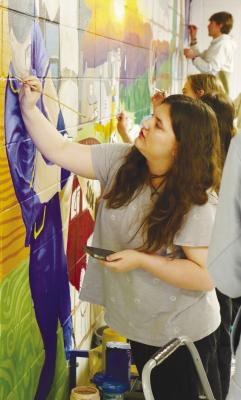 SAMANTHA CAUDILL was among the many St. Paul Public Schools students in Art 1–Art 4 to contribute to the mural painted in a high school hallway last week. The mural was the project of 2025 Artist in Residence Hugo Zamorano with the Nebraska Arts Council. Photo by Michael Rother