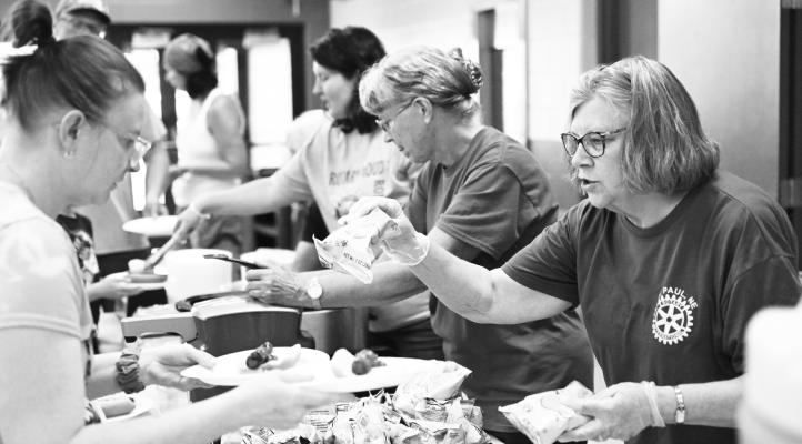MEMBERS of the Rotary Club of St. Paul helped welcome students back to class at St. Paul Public Schools with a free hot dog meal during last Tuesday night’s back to school open house. A large crowd attended the open house and enjoyed the Rotary Club’s hospitality.