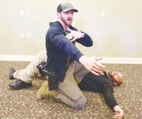 HOWARD COUNTY SHERIFF’S OFFICE Sergeant Paul Tartaglia, with help from St. Paul Police Chief Dan Howard, demonstrates how to apply a tourniquet to a bicep wound during last week’s Stop the Bleed demonstration. Photos by Michael Rother