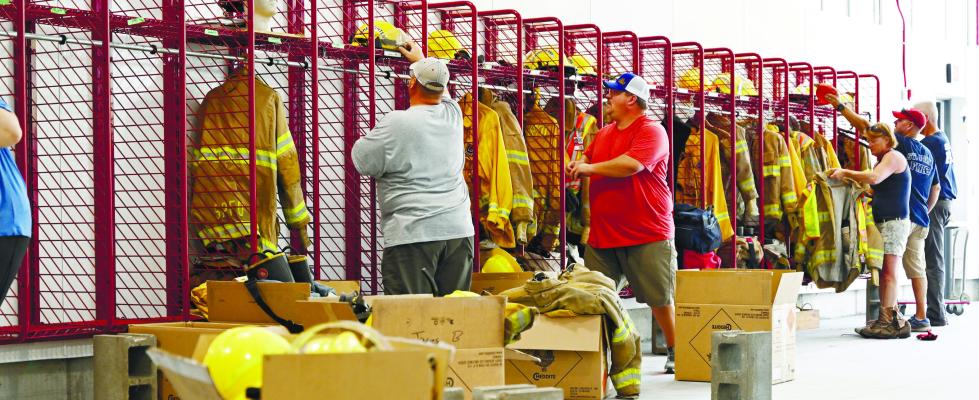 MEMBERS of the St. Paul Volunteer Fire Department work to unpack their gear on Saturday afternoon at the new fire station in St. Paul. Around twenty-five to thirty members of the department helped move into the fire station over the weekend. Photos by Michael Happ