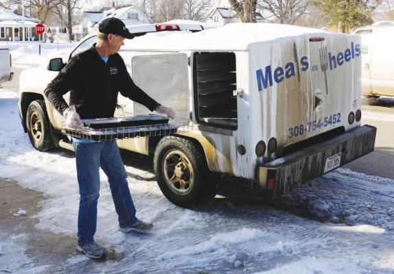 ST. PAUL SENIOR CENTER volunteer Dave Harrington loads a tray of meals for the St. Paul Senior Center’s Home Delivered Meals Program into one of the center’s two Hot Shots. (Michael Rother)