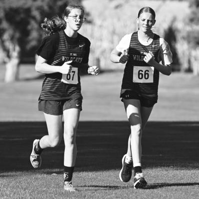 ST. PAUL’S Julia Kleinsasser and Autumn Doncheske finished nearly in lockstep at the Cardinals’ cross country invitational last week at the Albion Country Club. Photos by Michael Happ